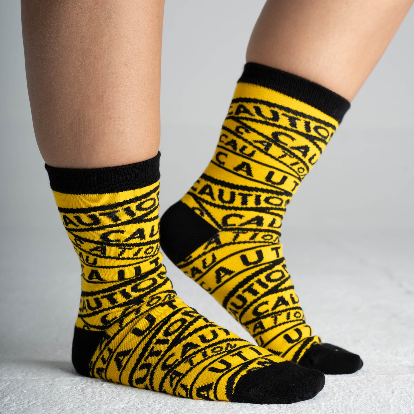 Yellow caution socks by Dank N Drip with bold black warning stripes – trendy streetwear socks for men and women